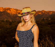 Load image into Gallery viewer, Woman wearing a straw cowboy hat with a red band facing front.
