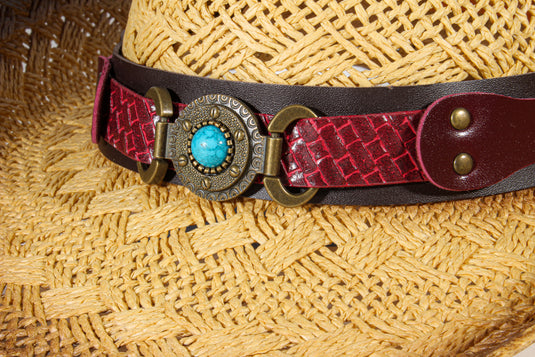Close-up of the red band with circular bead ornament of a straw cowboy hat.